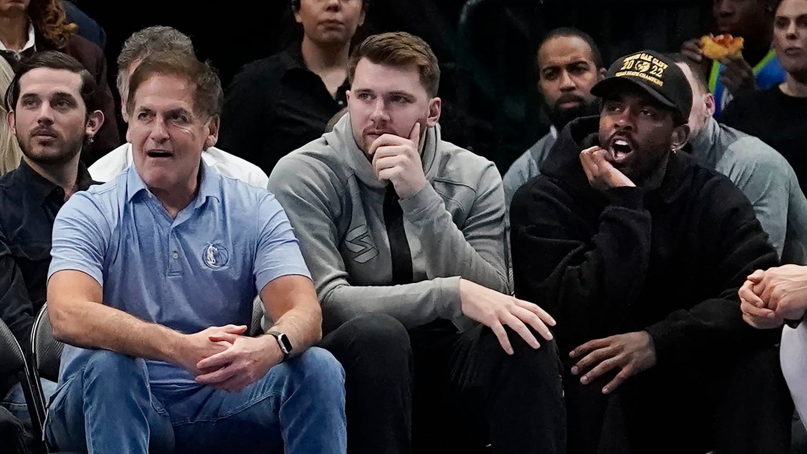 Dallas Mavericks team owner Mark Cuban, left, sits with players Luka Doncic, center, and...