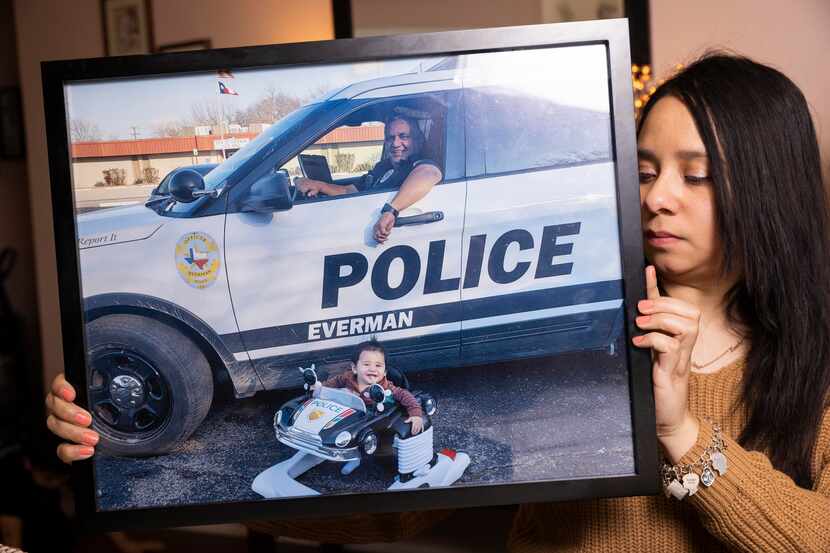 Annette Arango holds a family photo of her father, Alex Arango, an officer with the Everman...