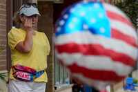 FILE - A woman wipes away tears after a mass shooting at an Independence Day parade that...