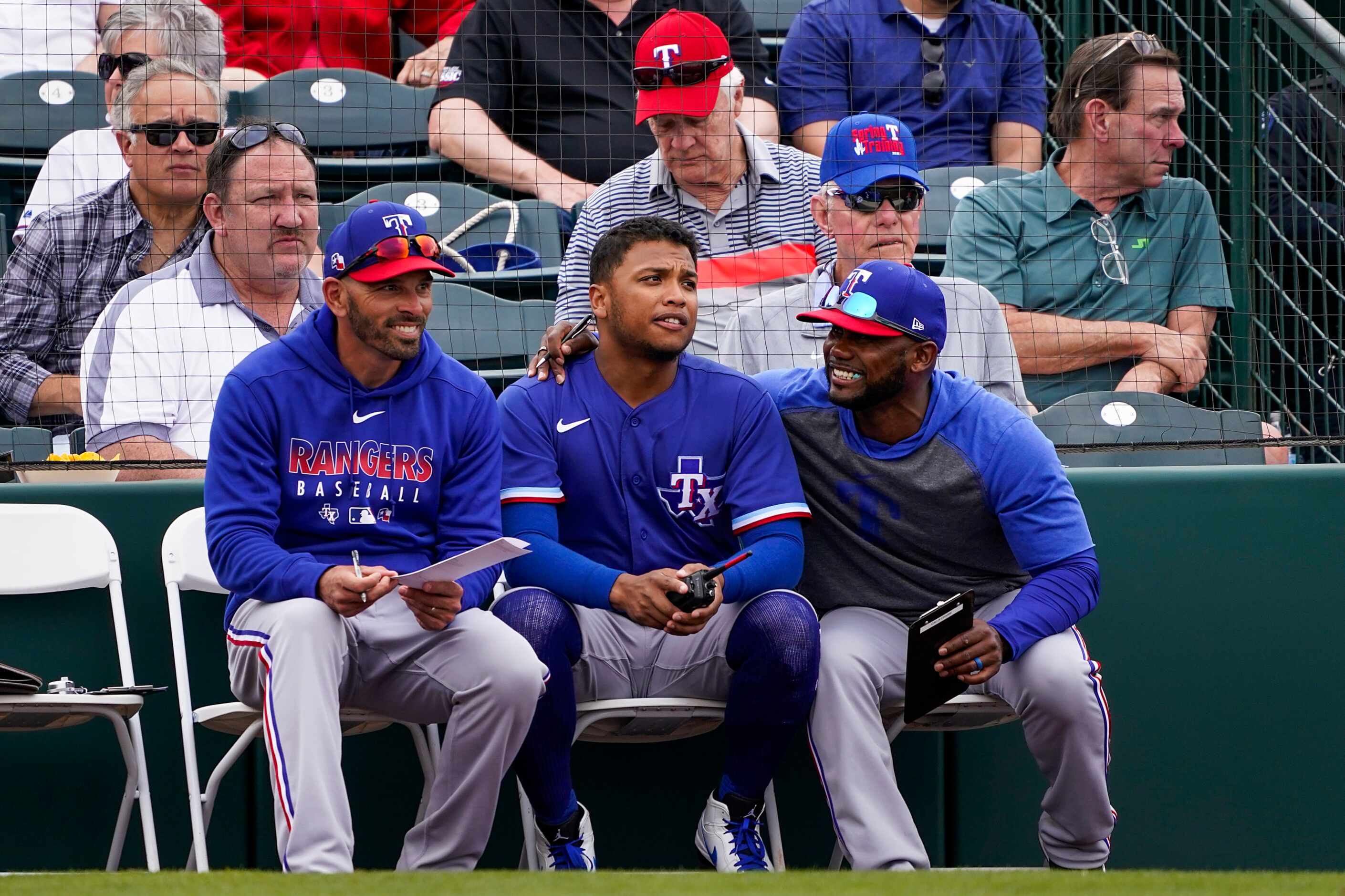 Texas Rangers outfielder Willie Calhoun (center) talks with assistant hitting coach Callix...