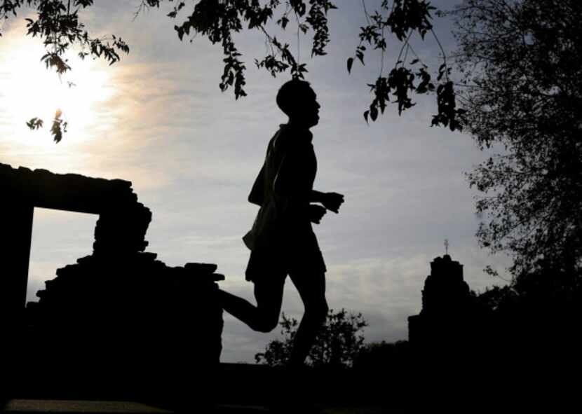 A runner in the San Antonio Marathon goes by Mission Espada during the early morning hours...