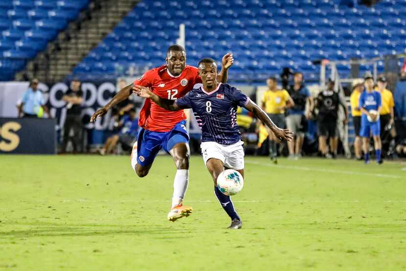 Bryan Oviedo of Bermuda is chased by Costa Rica's Joel Campbell at the 2019 Gold Cup at...