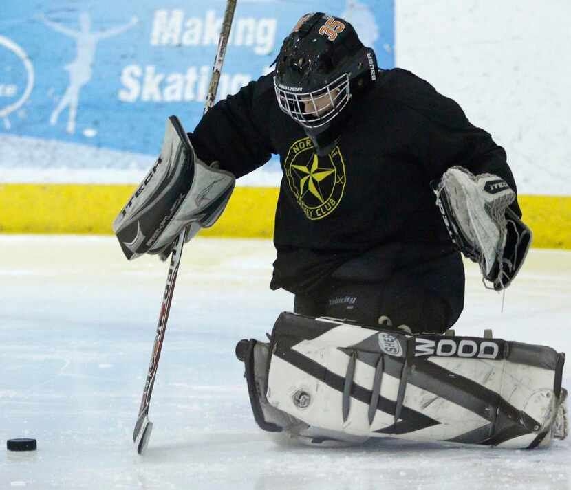 
Goalie Devin Cox reaches out to block a puck during camp. 
