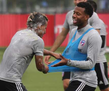 FILE - FC Dallas player Michael Barrios, left, tangles good-naturedly with teammate Kellyn...
