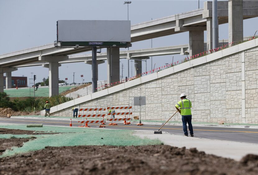 A construction worker sweeps the sidewalk at the intersection of Interstate 35W and 4th Street.