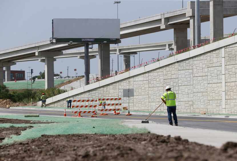 A construction worker sweeps the sidewalk at the intersection of Interstate 35W and 4th Street.