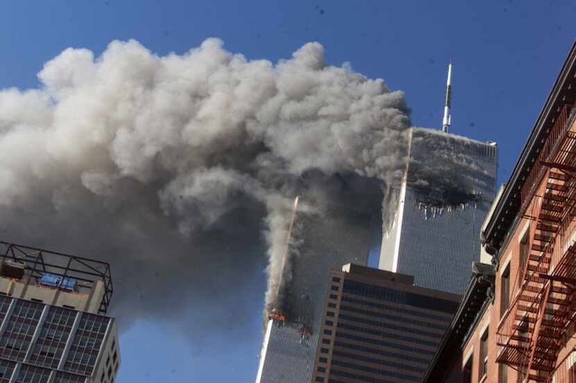 Smoke rises from the burning twin towers of the World Trade Center after hijacked planes...