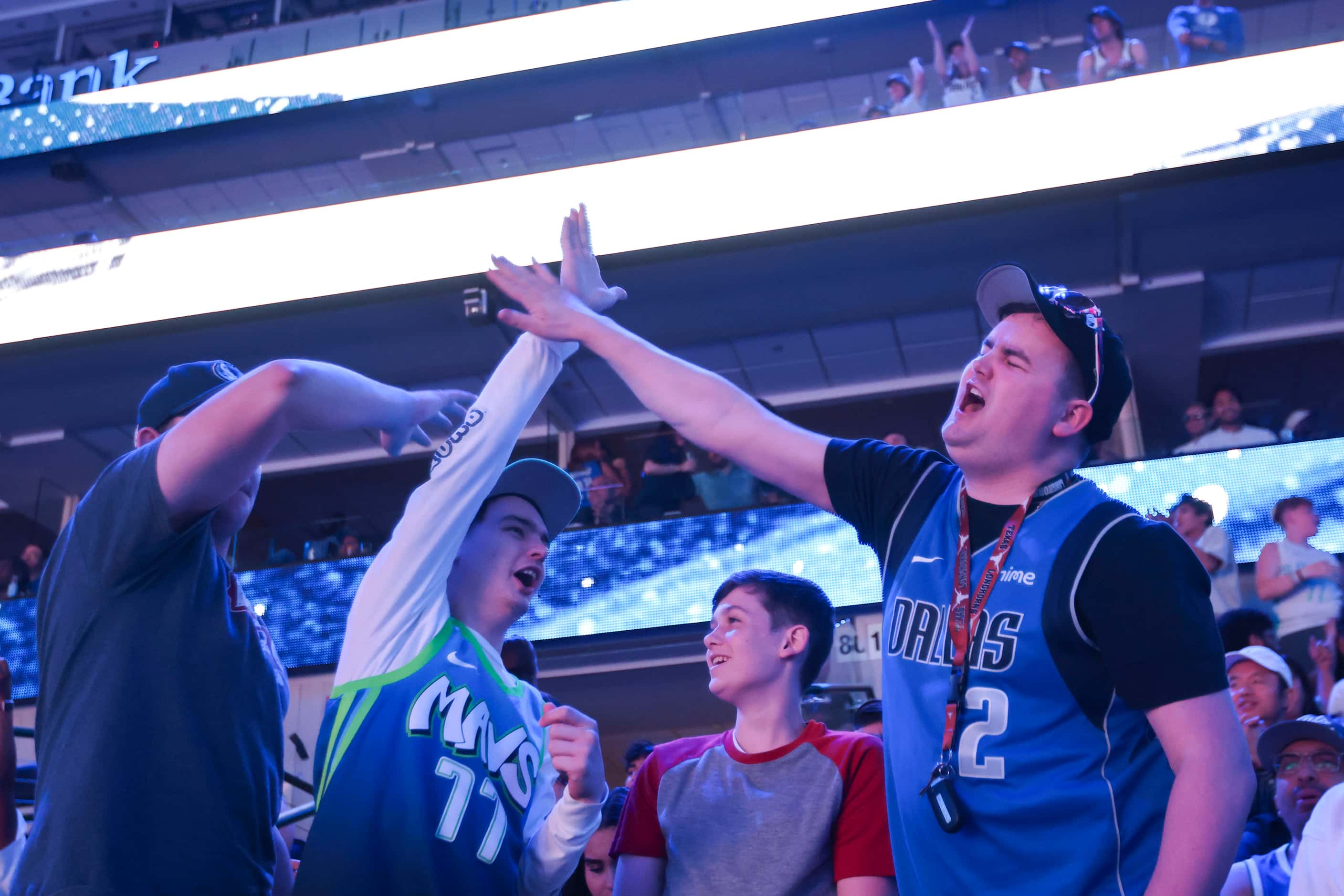 Dallas Mavericks fan Sean Palmore (left) with others cheer followed by a point in the first...