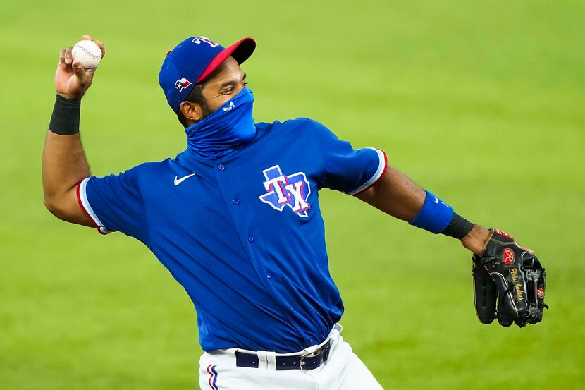 Texas Rangers shortstop Elvis Andrus wears a face mask as warms up before an exhibition game...