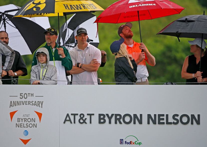 Fans wait in the rain at the first hole during the final round of AT&T Byron Nelson at...