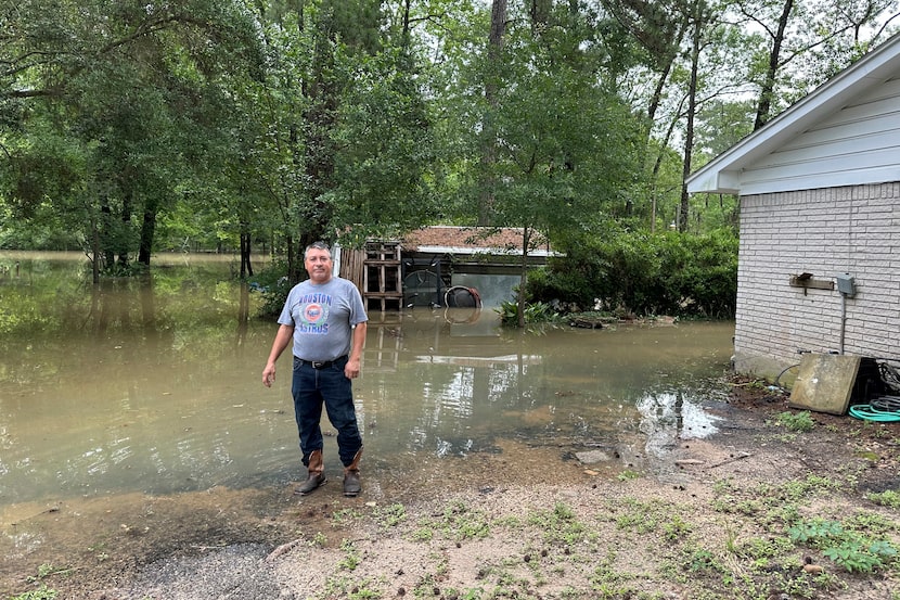 Miguel Flores Sr. stands in his flooded backyard outside his home in the northeast Houston...