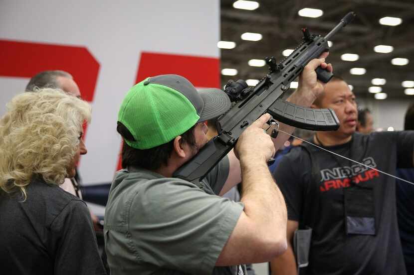 A man inspected a firearm in an exhibit hall at the Kay Bailey Hutchison Convention Center...