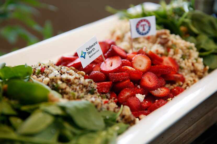 This healthy Globe Life Park salad features strawberries, quinoa, baby spinach and toasted...