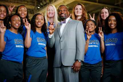 New women's basketball head coach Travis Mays poses for a photograph with his team after he...