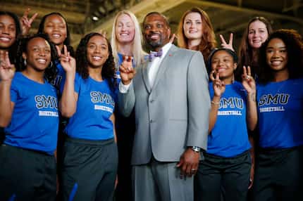 New women's basketball head coach Travis Mays poses for a photograph with his team after he...