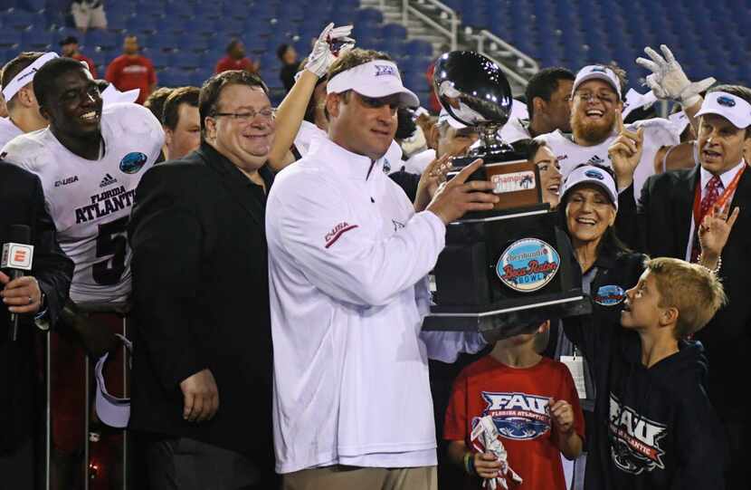 Florida Atlantic head coach Lane Kiffin holds the Boca Raton Bowl trophy after beating Akron...