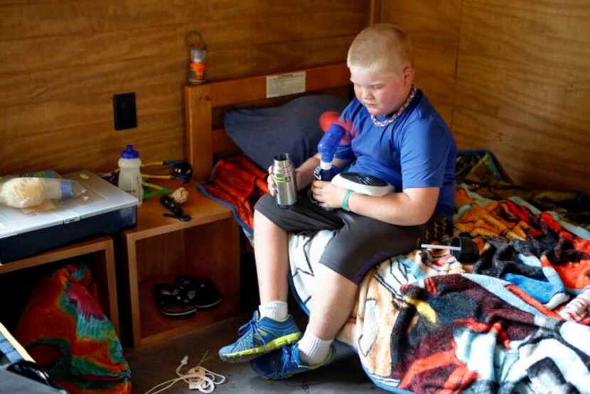 
Payton Stewart, 9, who lost his father to a heart attack, cools off with a fan during quiet...