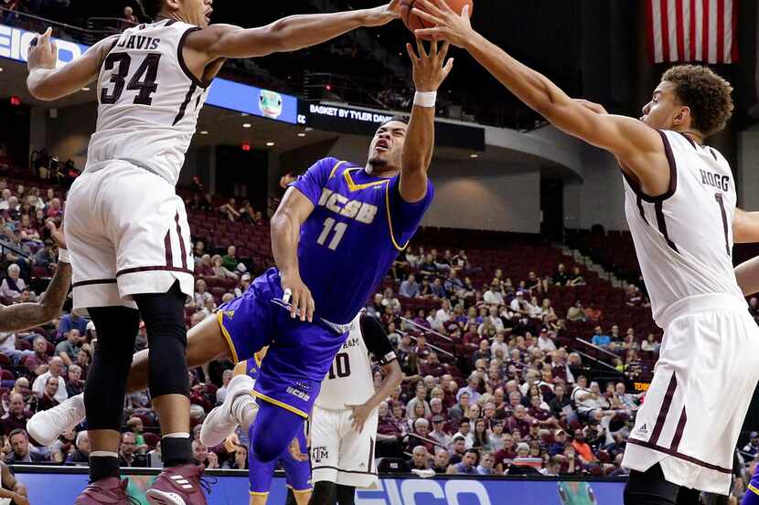 UC Santa Barbara guard Brandon Davis (11) has his shot blocked by Texas A&M center Tyler...