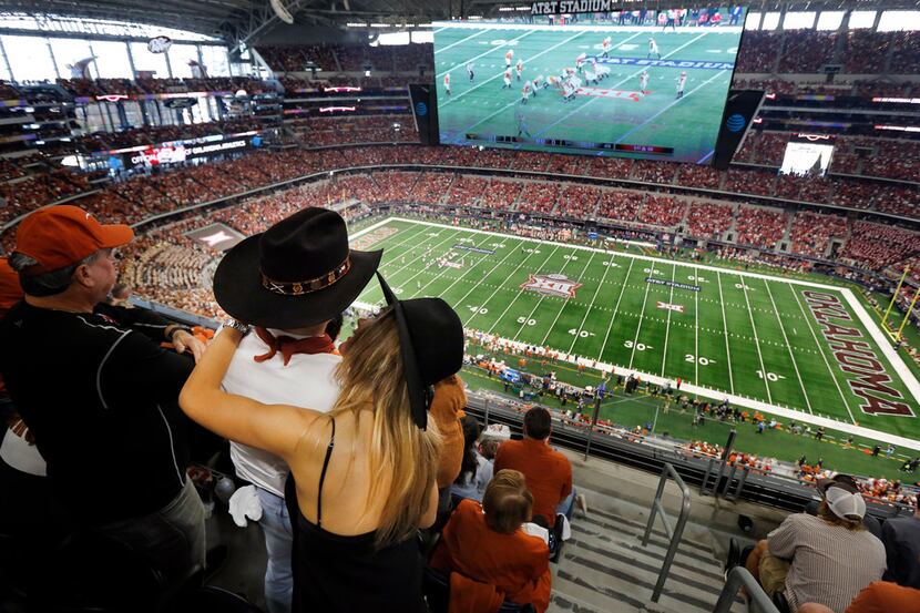A Texas Longhorn couple embrace during the Big XII Championship game at AT&T Stadium in...
