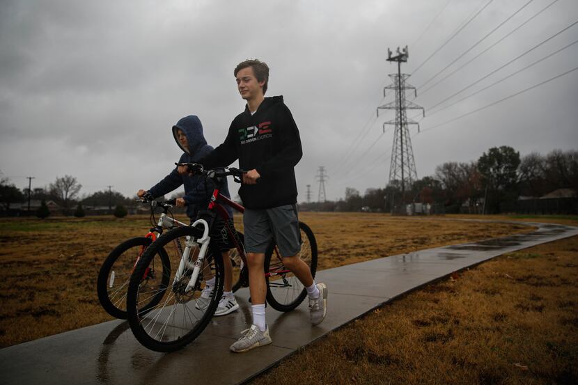 (From left) Henry Webb, 11, and his brother Jack, 14, walk to their mother's SUV after...