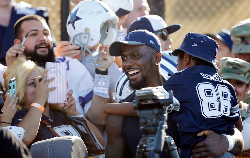 Dallas Cowboys wide receiver Dez Bryant (88) holds a crying Joshua Williams, 9, after he...