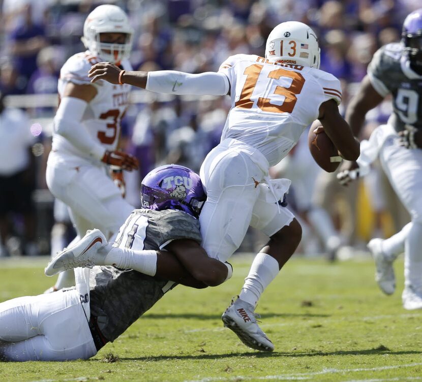 Texas Longhorns quarterback Jerrod Heard (13) is tackled by TCU Horned Frogs linebacker...