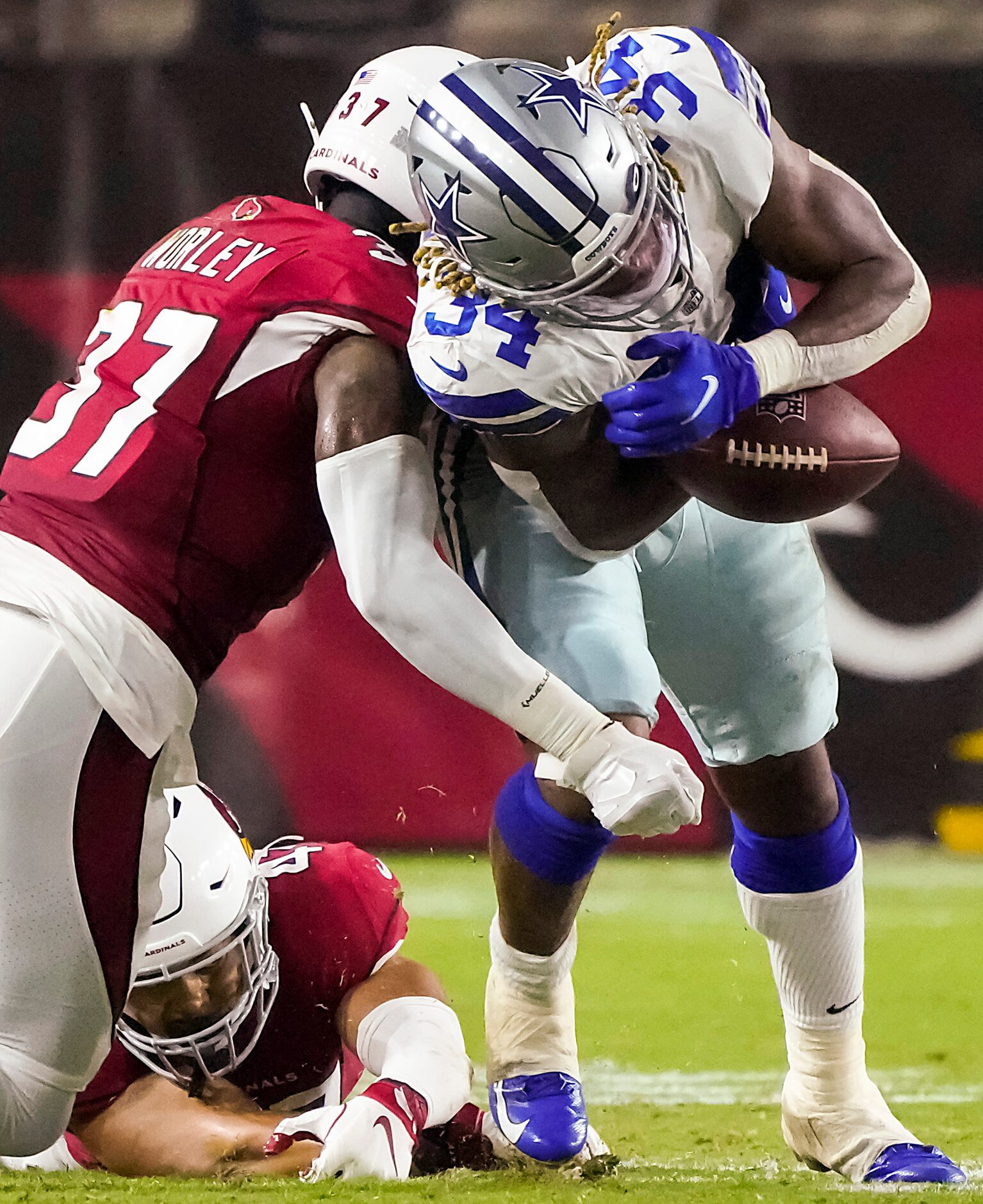 Dallas Cowboys running back Rico Dowdle (34) fumbles as he is hit by Arizona Cardinals...