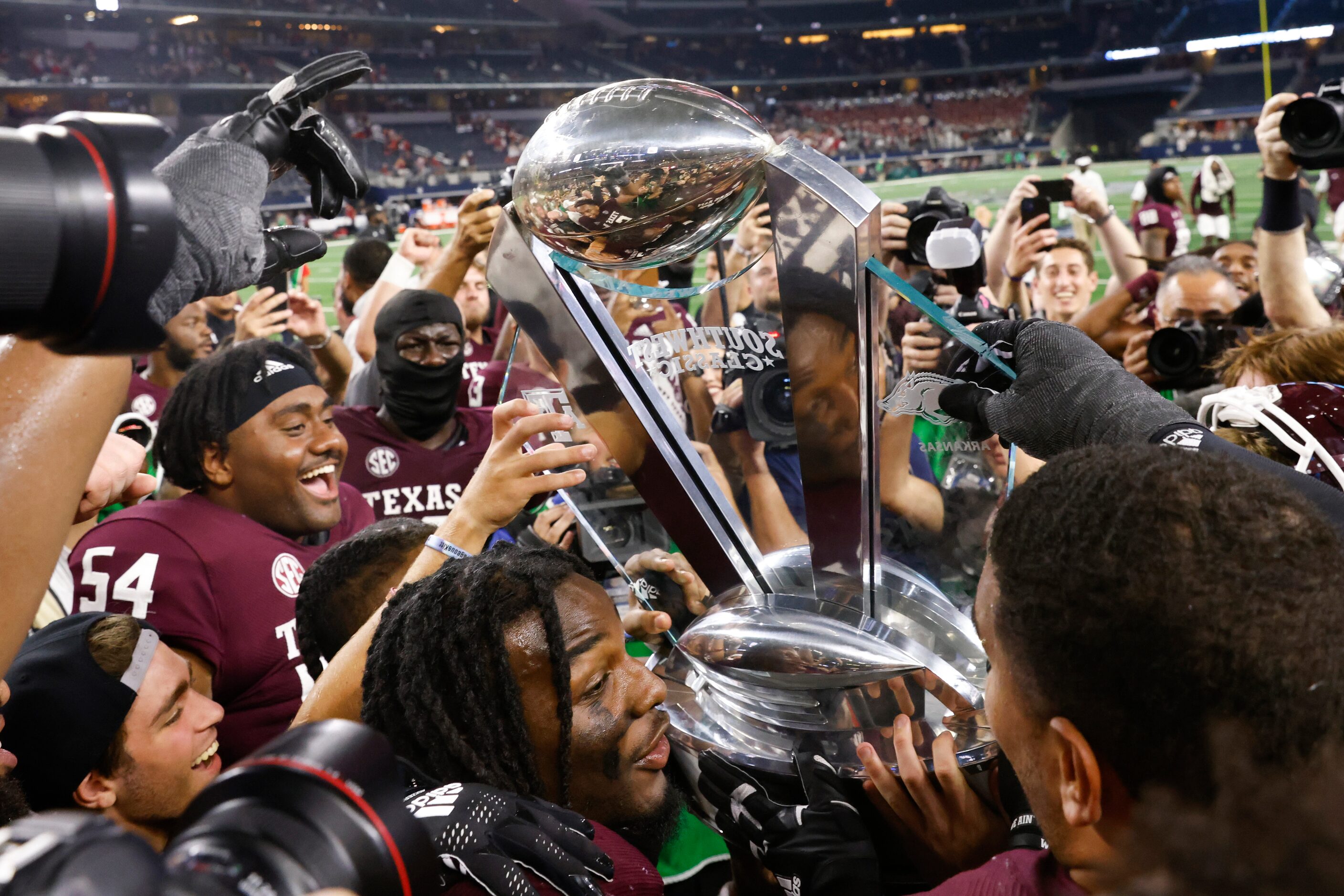 Texas A&M players celebrate after winning against Arkansas at AT&T Stadium in Arlington on...