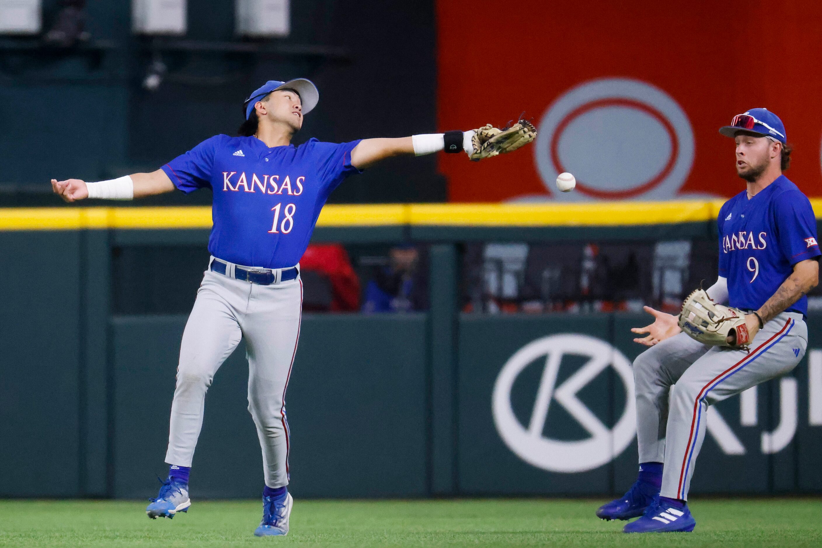 Kansas infielder Kodey Shojinaga (18) misses to catch of Kansas St. infielder Kaelen...