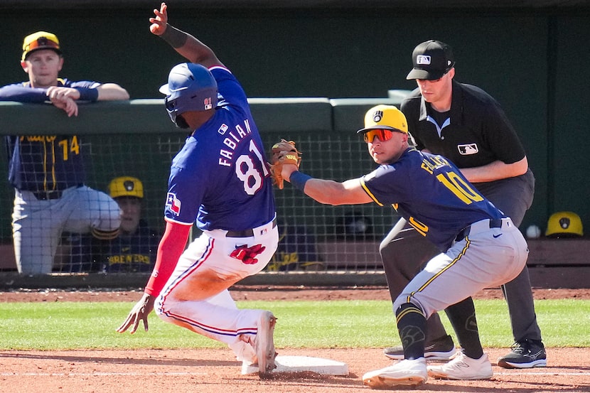 Texas Rangers outfielder Sandro Fabian was safe at third base ahead of the tag from...