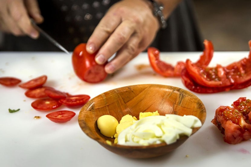 Monica slices Roma tomatoes for the ropa vieja.