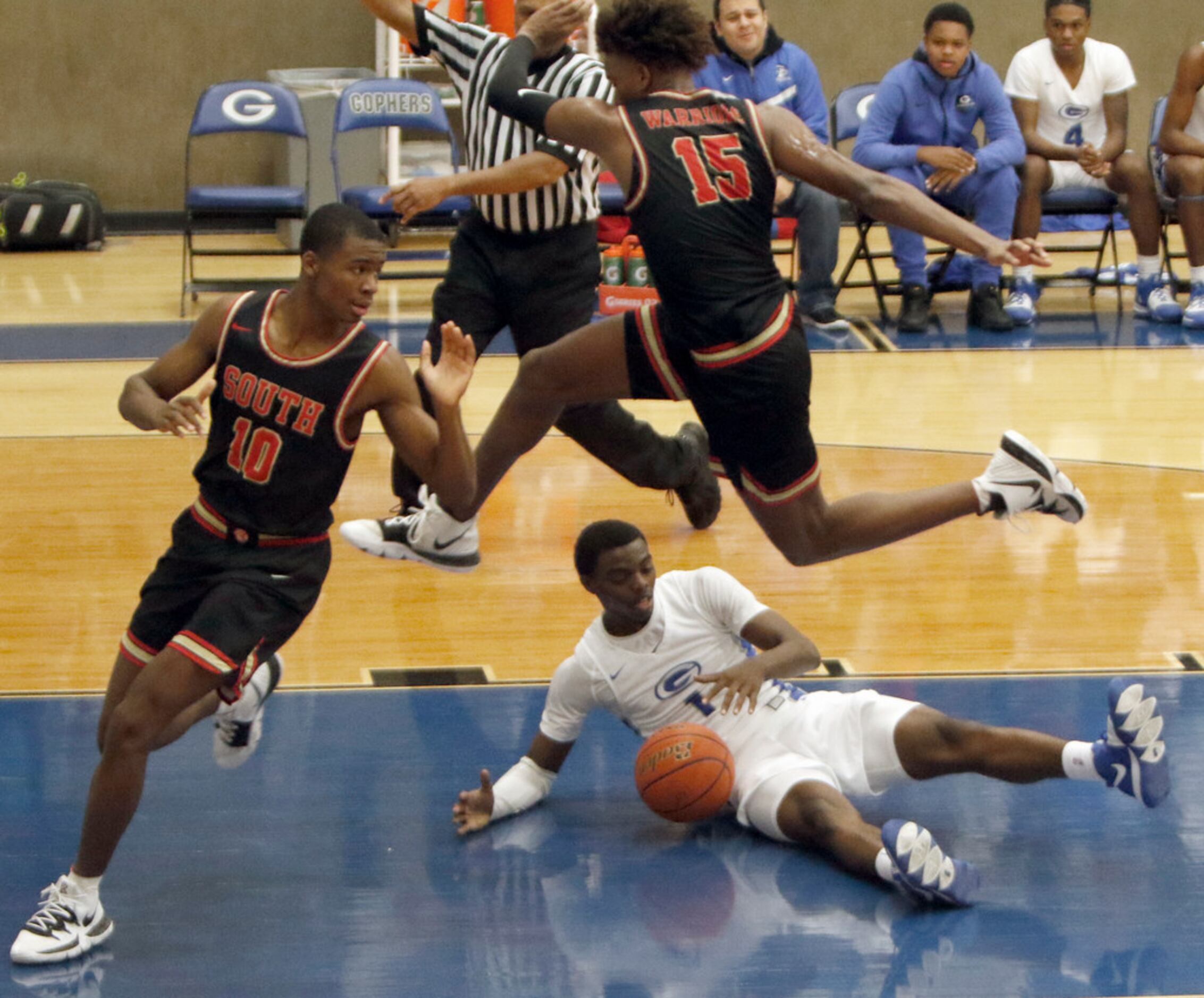 Grand Prairie's Jaylin Posey (1) is fouled by high flying South Grand Prairie forward...