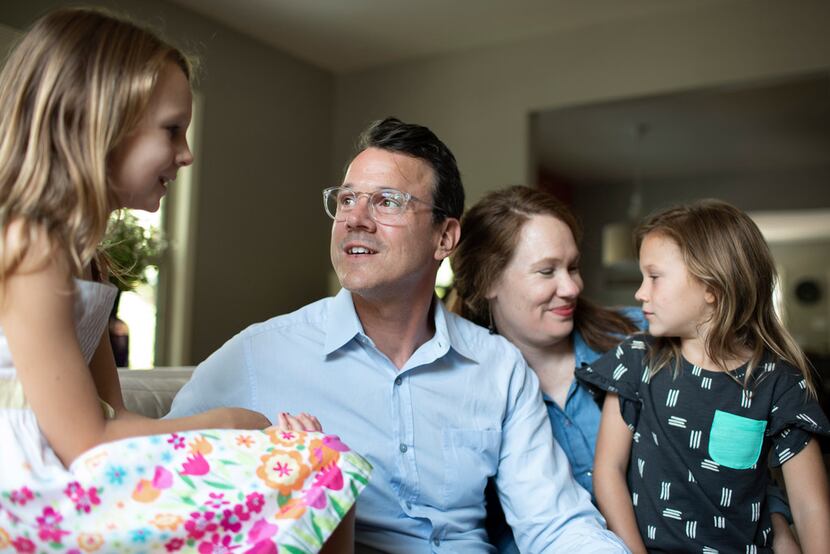 Drew Calver sits with his wife Erin and daughters Eleanor, 7, and Emory, 6, in their home...