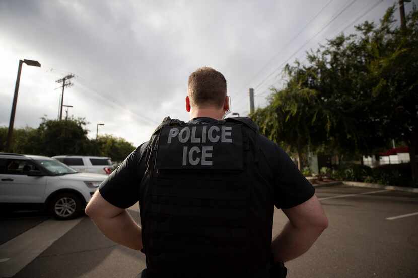 A U.S. Immigration and Customs Enforcement officer looks on during an operation in...