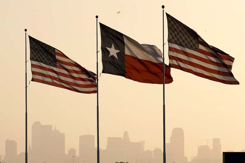 Stiff south winds blow into North Texas and downtown Dallas as Texas and U.S. flags fly...