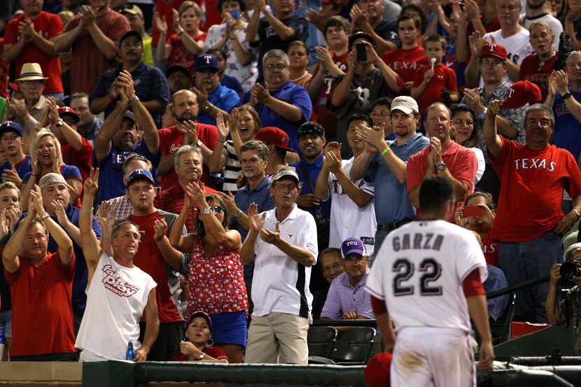 Texas Rangers fans cheer Texas Rangers starting pitcher Matt Garza (22) as he leaves the...