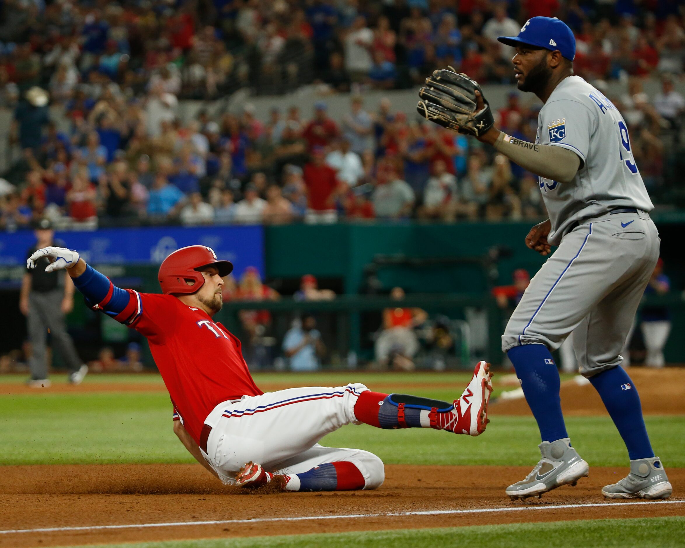 Texas Rangers first baseman Nate Lowe (30) slides into third base ahead of Kansas City...