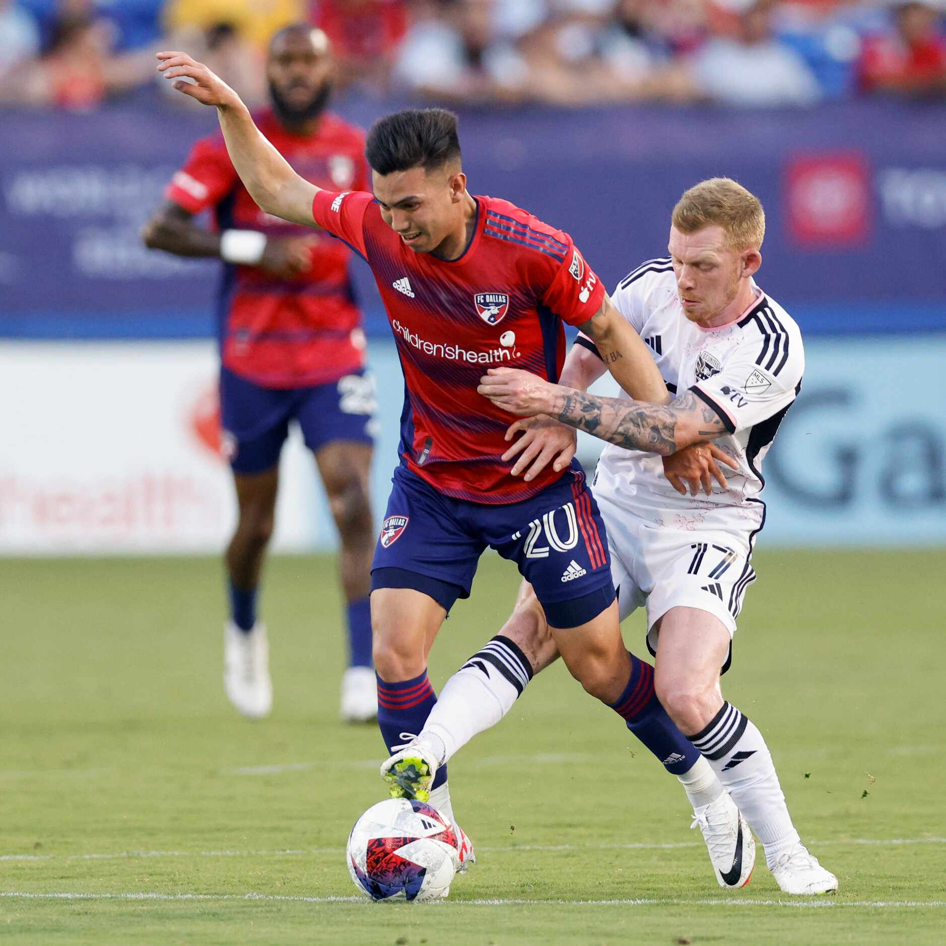D.C. United midfielder Lewis O'Brien (17) reaches for the ball between the legs of FC Dallas...