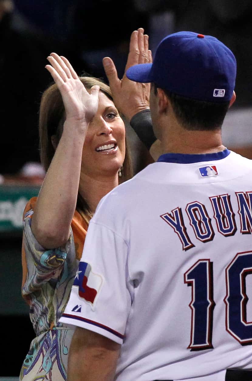 Fox Sports reporter Emily Jones slaps hands with Texas Rangers Michael Young after their win...