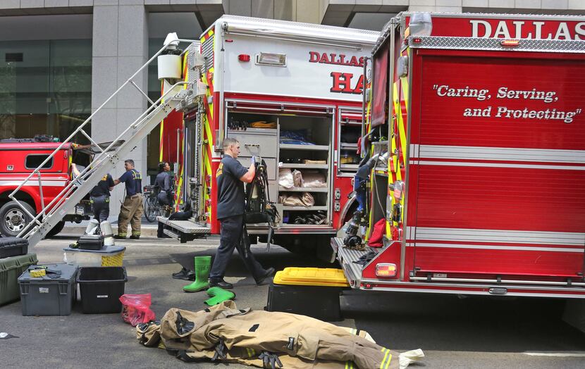 Firefighters pack up their equipment after a false alarm at a downtown Dallas high-rise....