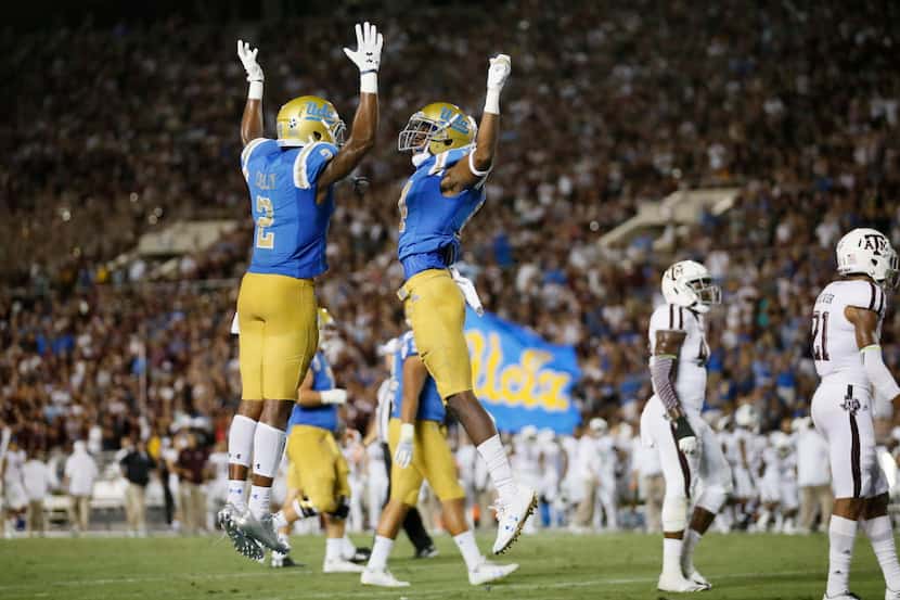 UCLA wide receiver Theo Howard, right, celebrates scoring a touchdown with UCLA wide...