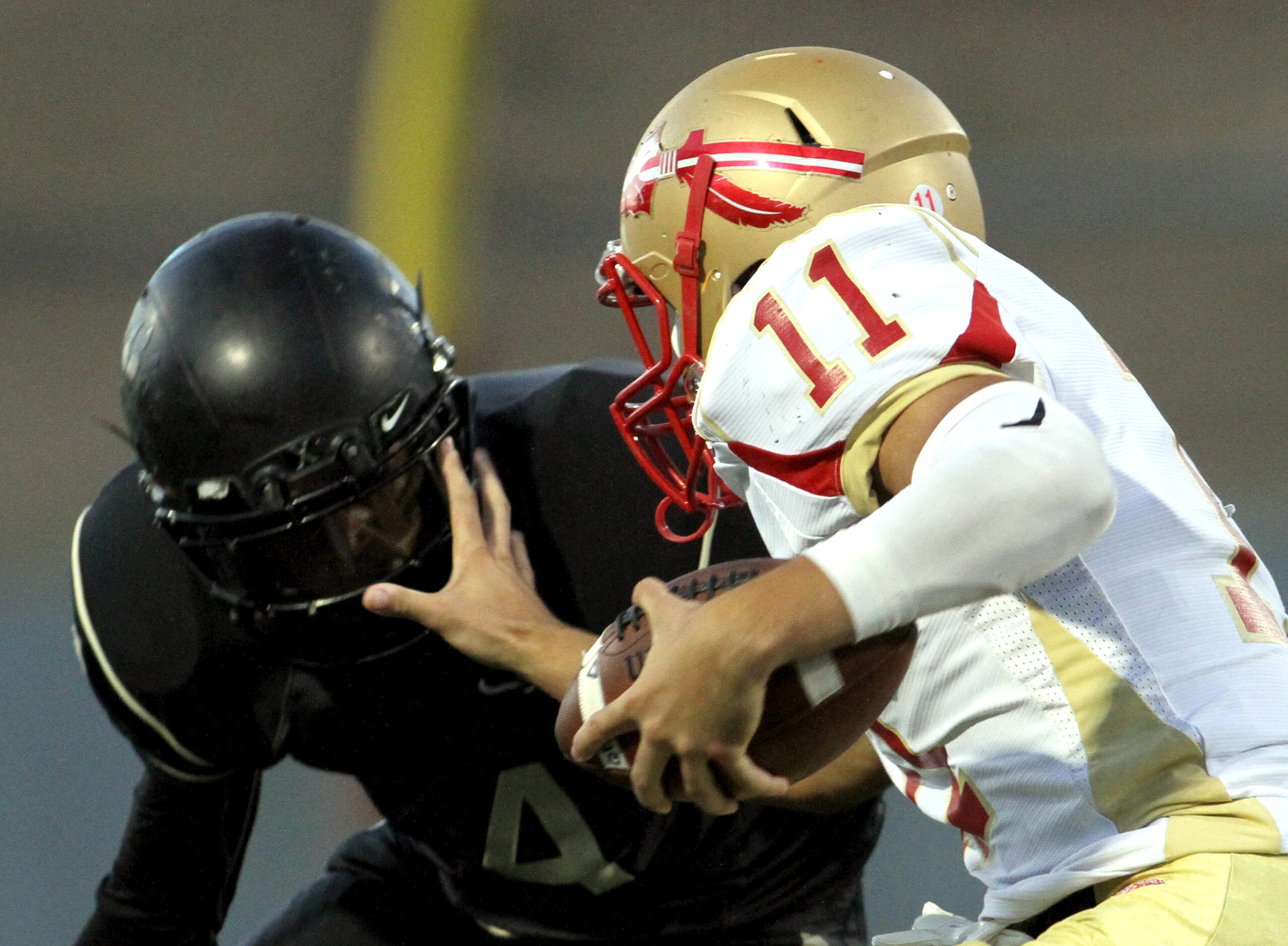 South Grand Prairie quarterback Greg Eisworth (11) stiff-arms South Oak Cliff defensive back...