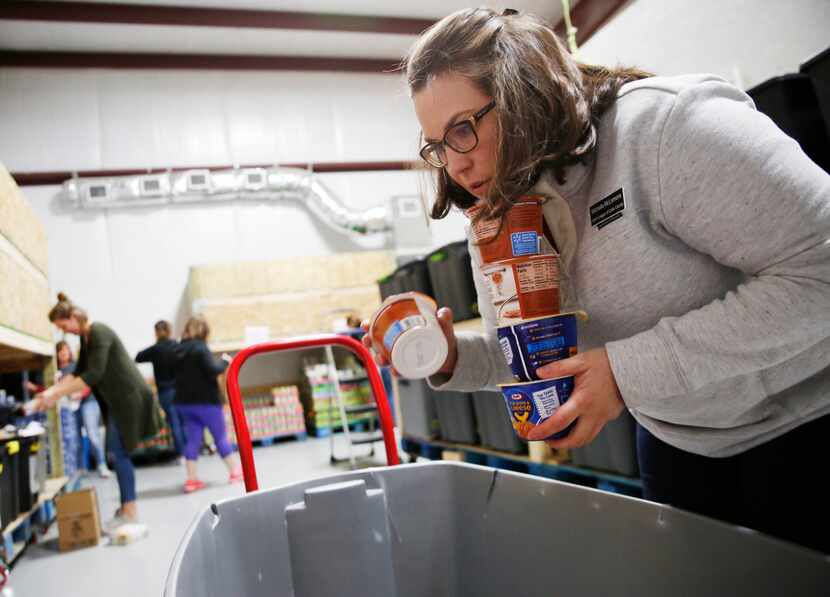 Volunteer Michelle McLemore organizes donated food items before assembling meals for...