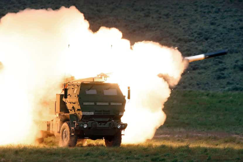 FILE - A launch truck fires the High Mobility Artillery Rocket System (HIMARS) produced by...