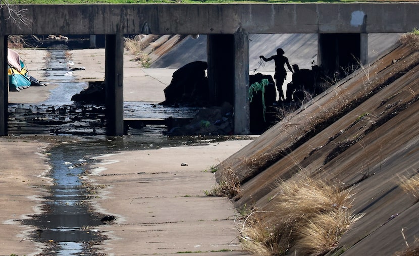 A couple organizes an encampment built in the concrete drainage culvert of Joe’s Creek below...