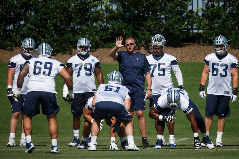FILE - Cowboys assistant offensive line coach Marc Colombo works with lineman during the...