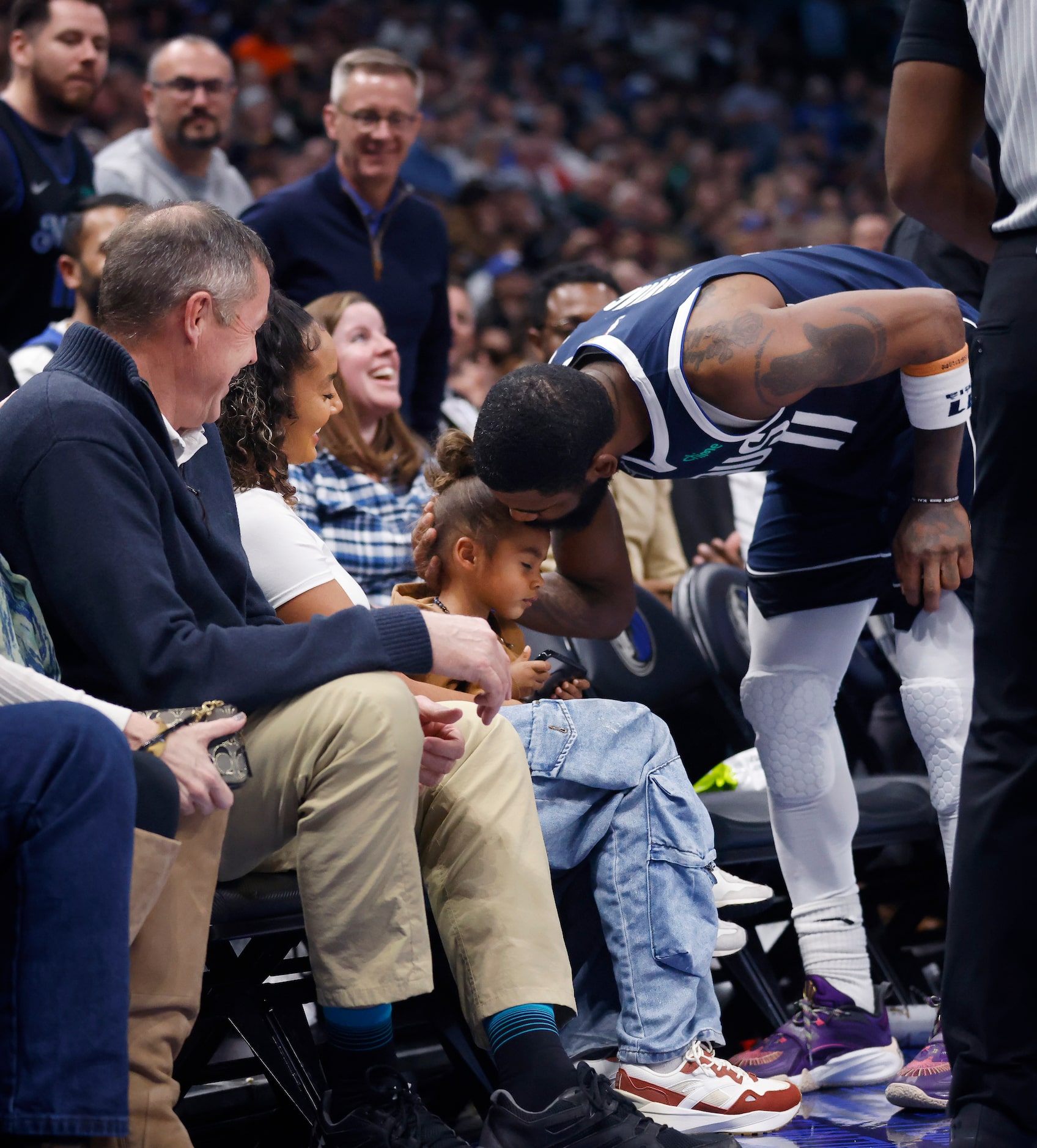 Dallas Mavericks guard Kyrie Irving (11) gives his son a kiss on the bench after Washington...