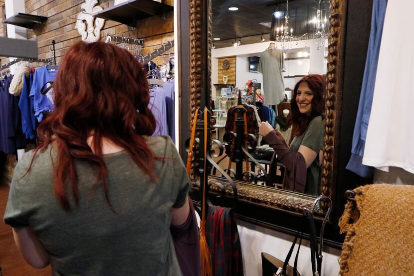 Katie Berry, 22, tried on a top at Apricot Lane at Galleria Dallas on Black Friday. (David...
