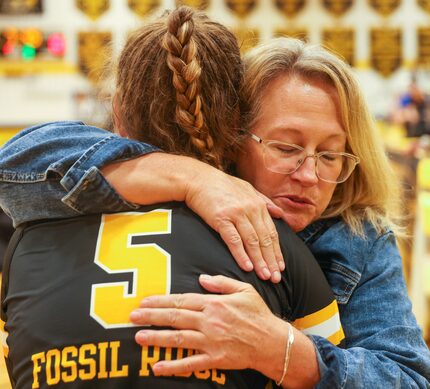 Fossil Ridge High School defensive specialist Ruslana Plaksii (5) receives a hug from...