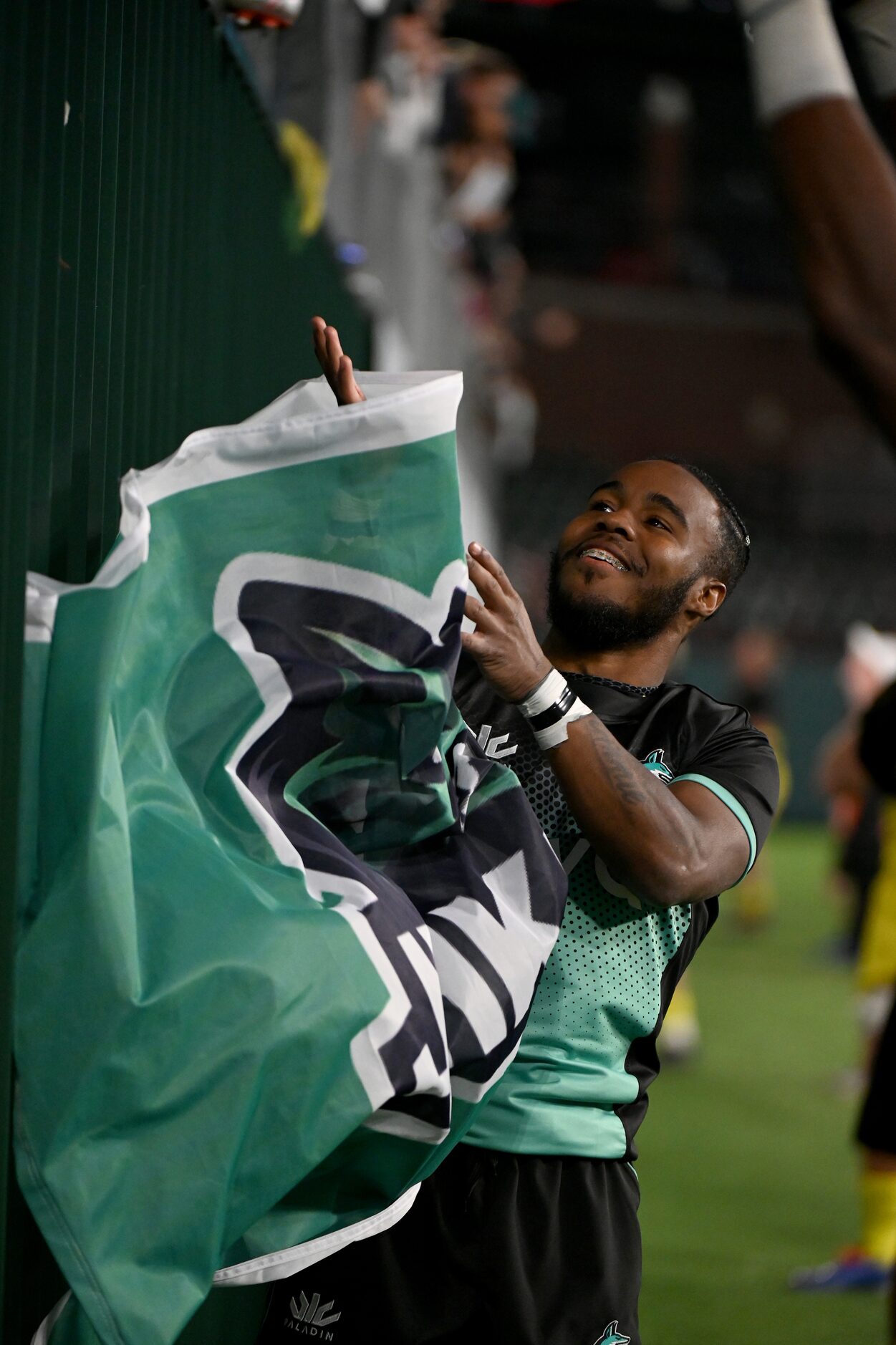 Dallas’ Aaron Gray (11) grabs a Dallas Jackals flag to pose a photo after a Major League...